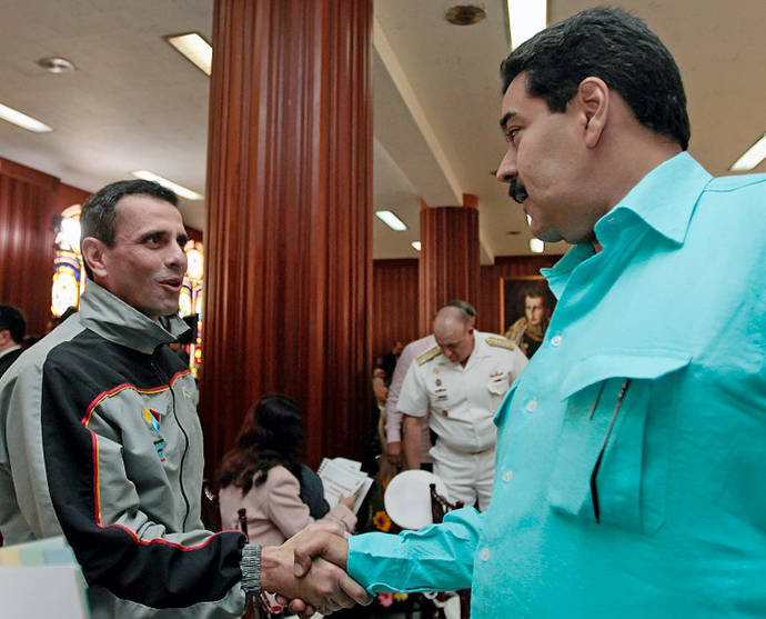Venezuelan Vice President Nicolas Maduro (R) greeting oppposition leader and governor of the Miranda state Henrique Capriles Radonski (C) during the meeting of the Federal Council of Government, in Caracas on January 15, 2013. (AFP Photo)