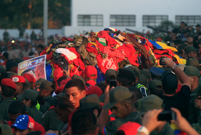 The coffin of late Venezuelan leader Hugo Chavez covered with clothes that people have thrown at it, is driven through the streets of Caracas, after leaving the military hospital where he died of cancer, March 6, 2013 (Reuters / Edwin Montilva)