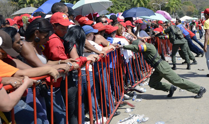 Venezuelan soldiers push the protective fences as supporters wait in line to pay last respects to the late Venezuelan President Hugo Chavez. (AFP Photo / Leo Ramirez)