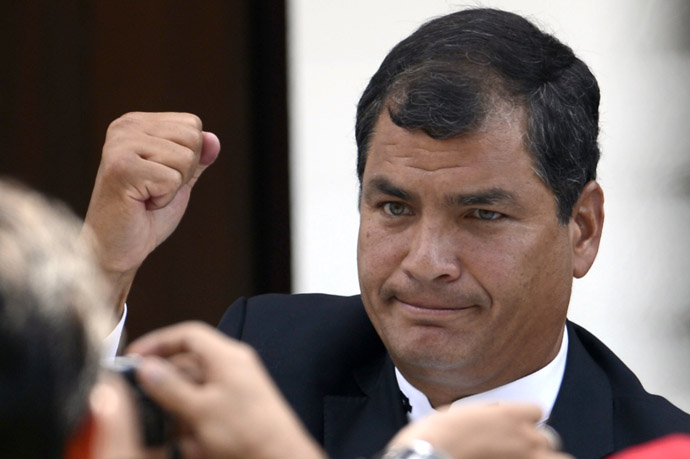 Ecuador's President Rafael Correa raises his clenched fist in salutation during the funeral of Venezuela's President Hugo Chavez in Caracas, on March 8, 2013. (AFP Photo/Juan Barreto) 