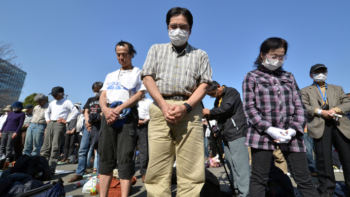 People pray in silence at the start of an anti nuclear rally in Tokyo on March 9, 2013 (AFP Photo / Yoshikazu Tsuno)