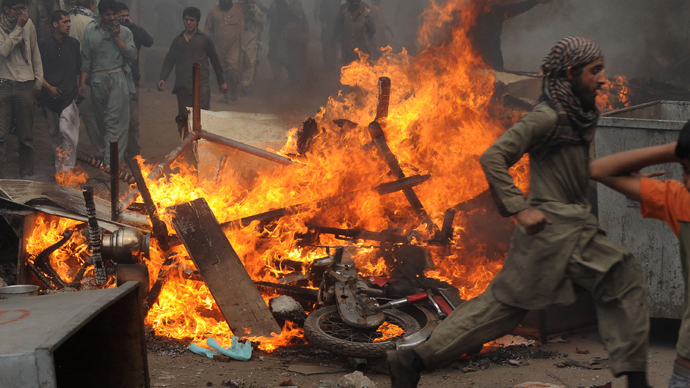  Angry Pakistani demonstrators gather around burning Christian's belongings during a protest over a blasphemy row in a Christian neighborhood in Badami Bagh area of Lahore on March 9, 2013 (AFP Photo / Arif Ali)