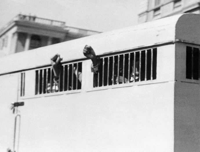 Eight men, among them anti-apartheid leader and African National Congress (ANC) member Nelson Mandela, sentenced to life imprisonment in the Rivonia trial leave the Palace of Justice in Pretoria 16 June 1964 with their fists raised in defiance through the barred windows of the prison car. (AFP Photo)
