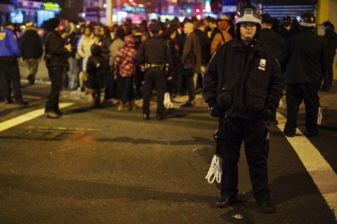 A New York Police Department (NYPD) officer watches a march protesting the NYPD shooting of 16-year-old Kimani Gray, in the Brooklyn borough of New York, March 11, 2013. Picture taken March 11, 2013. (Reuters/Lucas Jackson)