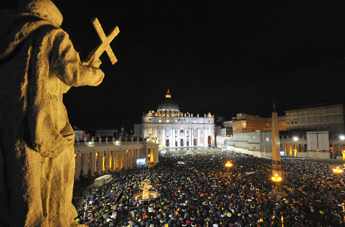 A general view shows the crowd on St Peter's square as white smoke rises from the chimney on the roof of the Sistine Chapel meaning that cardinals elected a new pope during the conclave on March 13, 2013 at the Vatican. (AFP Photo / Tiziana Fabi)