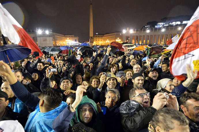 Faithful react as white smoke rises from the chimney on the roof of the Sistine Chapel meaning that cardinals elected a new pope on the second day of their secret conclave on March 13, 2013 at the Vatican. (AFP Photo / Alberto Pizzoli)