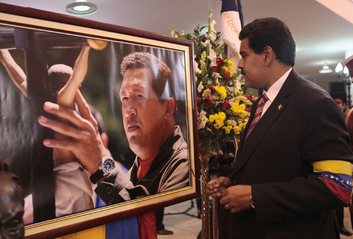 Acting Venezuelan President Nicolas Maduro (R) looks at a photograph of late Venezuelan President Hugo Chavez during the funeral at the military academy in Caracas in this picture provided by Miraflores Palace on March 8, 2013 (Reuters / Miraflores Palace / Handout) 