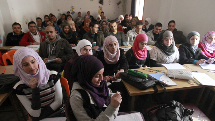 Palestinian refugees, some of whom fled the Yarmuk refugee camp in Damascus, attend class in the "Palestine" Palestinian refugee camp in the Syrian city of Homs (AFP Photo / Anwar Amro)