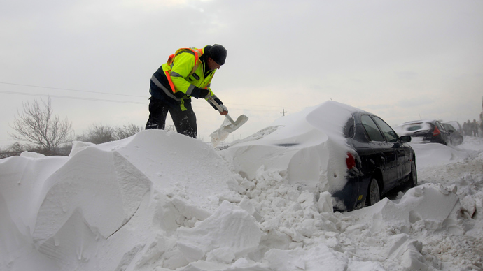 A member of the Hungarian rescue team removes snow from a car at the M1 highway, 80 km west of Budapest, March 15, 2013 (Reuters / Laszlo Balogh)