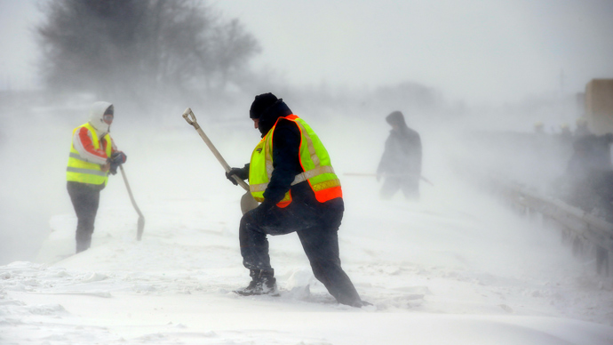 A member of the Hungarian rescue team removes snow from a car at the M1 highway, 80 km west of Budapest, March 15, 2013 (Reuters / Laszlo Balogh)