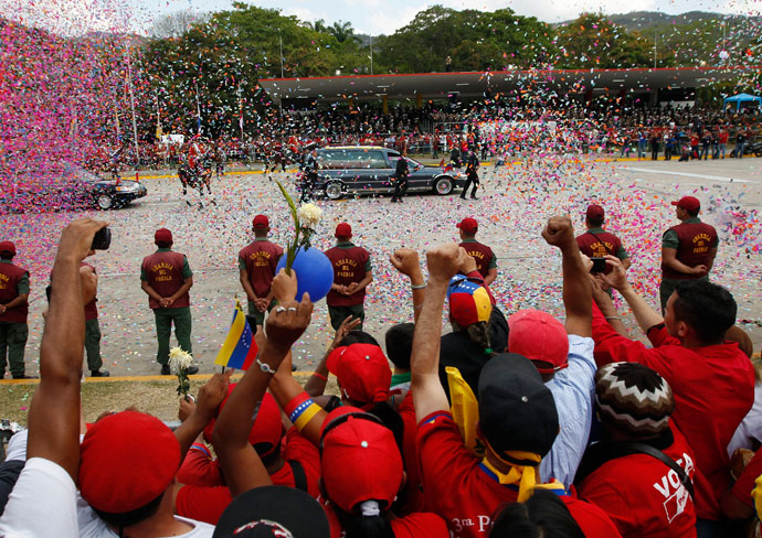 People react as the hearse carrying the body of Venezuela's late President Hugo Chavez drives past during his funeral parade in Caracas March 15, 2013.(Reuters / Tomas Bravo)