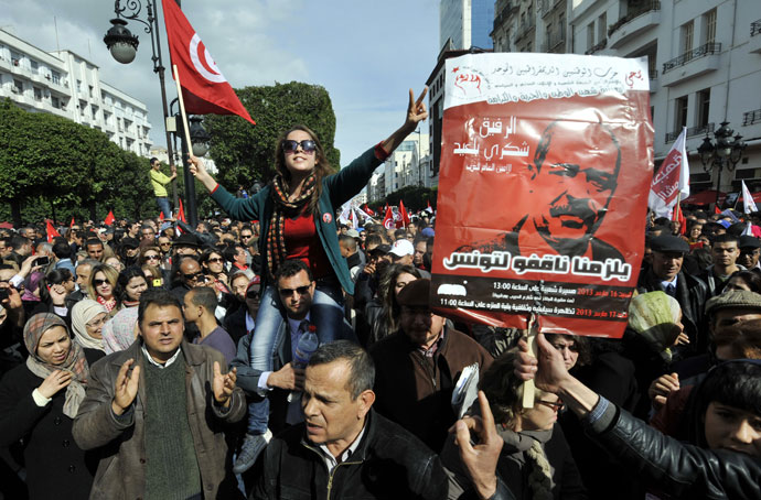 Tunisian people shoot slogans during a demonstration to mark the 40th day of mourning after the death of anti-Islamist opposition leader Chokri Belaid (featured on poster) on March 16, 2013.(AFP Photo / Fethi Belaid)
