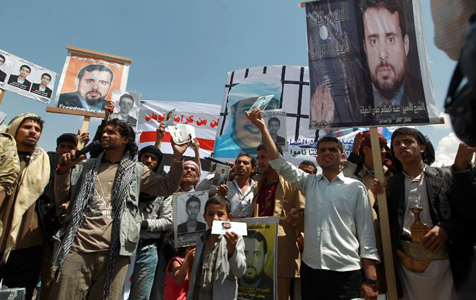 Relatives of Yemeni inmates held in the US detention center "Camp Delta" at the US Naval Base in Guantanamo Bay, Cuba, brandish their portraits during a protest to demand their release, outside the American Embassy in Sanaa. (AFP Photo / Mohammed Huwais)