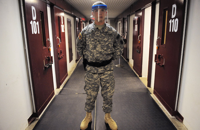 A guard wears a protective face shield, after he was asked to demonstrate its use by a correspondent, in the "Camp Five" detention facility at U.S. Naval Station Guantanamo Bay (Reuters)