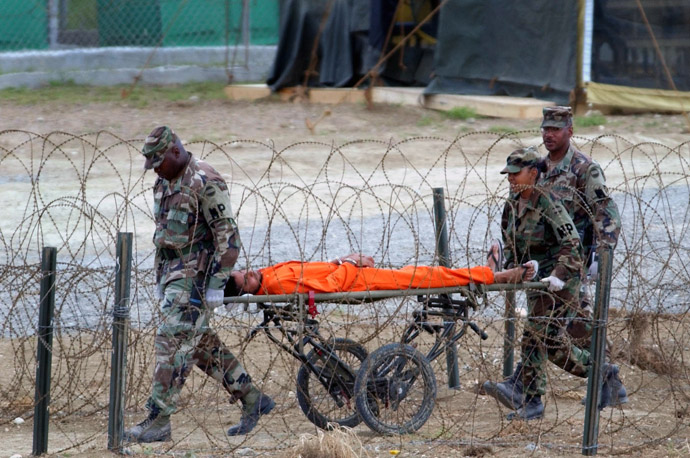 A detainee is carried by military police after being interrogated by officials at Camp X-Ray at the U.S. Naval Base at Guantanamo Bay, Cuba, Wednesday, Feb. 6, 2002. (Reuters)