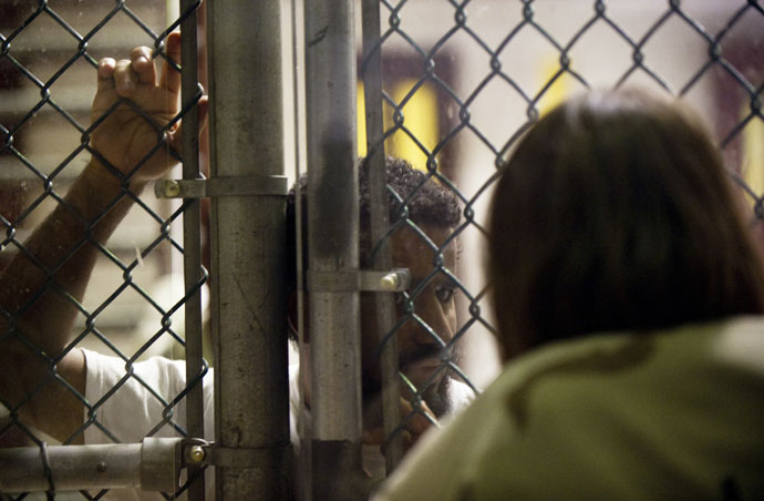 A detainee speaks with a US military guard (R) inside Camp VI at Guantanamo Bay, Cuba.(AFP Photo / Paul J. Richards)