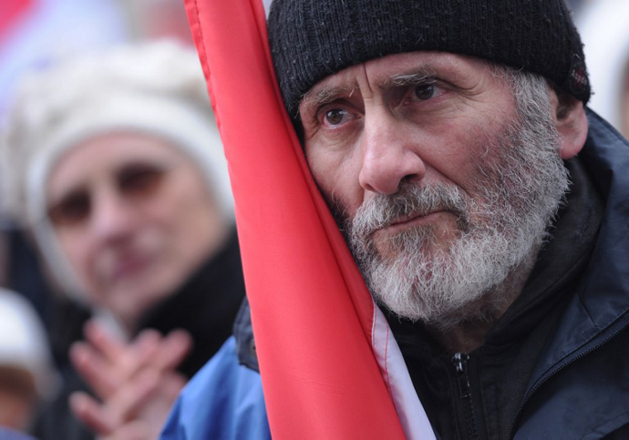 A protester holds an Hungarian flag during a demonstration of several thousand people who followed a call of the 'One million people for the freedom of press' organization at Calvin square in Budapest on March 17, 2013. (AFP Photo / Attila Kisbenedek)