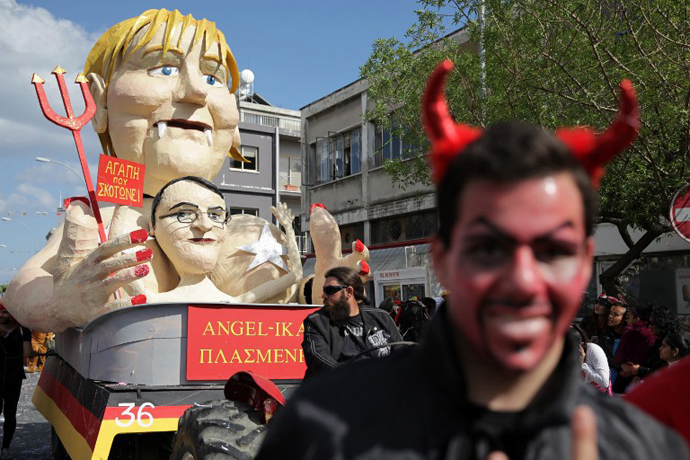 Cypriots walk past a papier-machÃ statue caricaturing German Chancellor Angela Merkel and President of Cyprus Nikos Anastasiadis, in an annual carnival in the southern city of Limassol, March 17, 2013. (AFP Photo / Yiannis Kourtoglou)