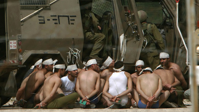 Israeli troops guard arrested Palestinian prisoners following an army raid on a prison compound in the West Bank town of Jericho to seize Palestinian militants. (AFP Photo / Pedro Ugarte)