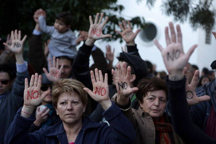 Cypriots show their palms reading "No" during a protest against an EU bailout deal outside the parliament in Nicosia on March 18, 2013. (AFP Photo / Patrick Baz)