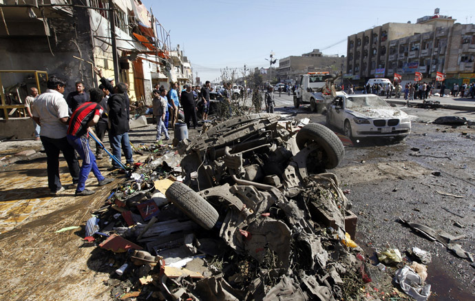 Residents gather at the site of a car bomb attack in the AL-Mashtal district in Baghdad March 19, 2013. (Reuters/Qahtan al-Sudani)