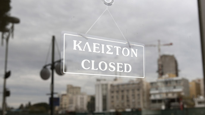 People are reflected at a glass door of a closed branch of Bank of Cyprus in Nicosia March 19, 2013. (Reuters)