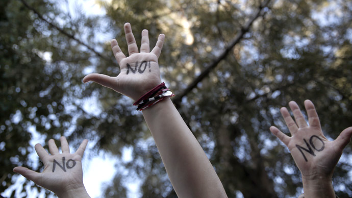 Protesters raise their open palms showing the world "No" during an anti-bailout rally outside the parliament in Nicosia March 18, 2013. (Reuters)