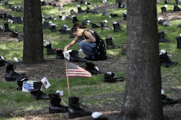 Michelle Rivas of Chicago looks at a set of combat boots placed in Grant Park 24 May, 2007 in Chicago, Illinois as part of the Eyes Wide Open: An Exhibition on the Human Cost of the Iraq War (AFP Photo)