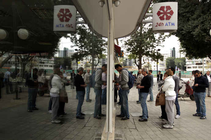 Cypriots and foreigners wait in line to withdraw money from an ATM of a Laiki (Popular) Bank branch in the old city of the capital, Nicosia, on March 21, 2013 (AFP Photo / Patrick Baz) 