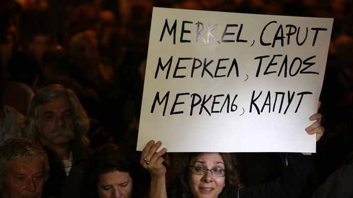 A Cypriot empoyee of the Laiki (Popular) Bank cries as she holds a placard reading in Greek, Russian and English "Merkel Caput" during a protest outside the Parliament on March 21, 2013 in Nicosia (AFP Photo / Patrick Baz)