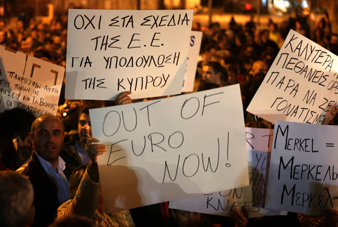 Cypriots hold placards during a protest outside the Parliament on March 21, 2013 in Nicosia (AFP Photo / Patrick Baz)