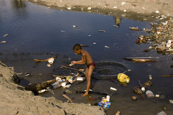 A boy plays in a pool of polluted water near the sea on a beach next to the main port in Haina.(Reuters / Eduardo Munoz)