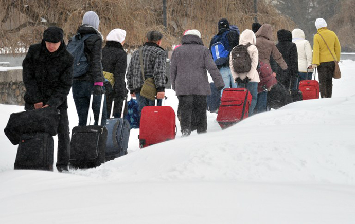 Tourists carry their luggage during a snow storm in the Ukraine capital Kiev on March 23, 2013. (AFP Photo / Sergei Supinsky)