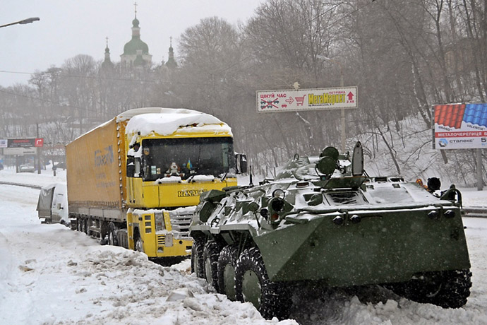 An armored personnel carrier tows a vehicle on a road covered with snow in Kiev on March 23, 2013. (AFP Photo)