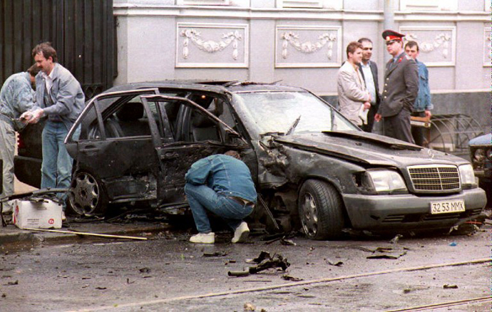 Police experts examine the remains of the car belonging to Boris Berezovsky, chairman of the Russian auto concern, "LOGOVAZ," whose driver was killed when the tycoon's Mercedes was blown up in Moscow 07 June 1994. (AFP Photo / Alexey Iliyn)