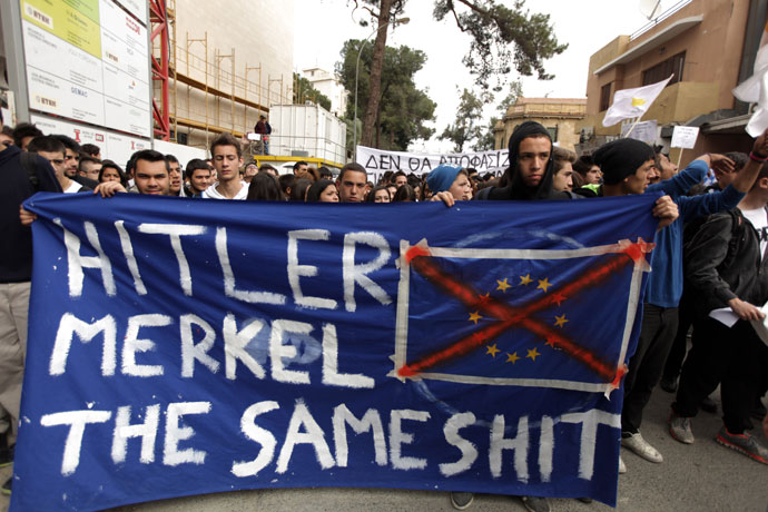 Cypriot college students hold a banner comparing German Chancellor Angela Merkel to Nazi dictator Adolf Hitler during a protest in Nicosia against a bailout for the financially crippled island on March 26, 2013.(AFP Photo / Patrick Baz)