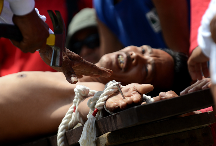 A penintent is nailed to a cross during the reenactment of crucifixion on Good Friday in the village of San Juan, San Fernando City, north of Manila on March 29, 2013 (AFP Photo / Noel Celis)