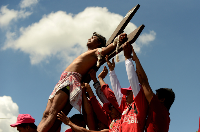 A penintent is nailed to the cross during the reenactment of crucifixion on Good Friday in the village of San Juan, San Fernando City, north of Manila on March 29, 2013 (AFP Photo / Noel Celis)