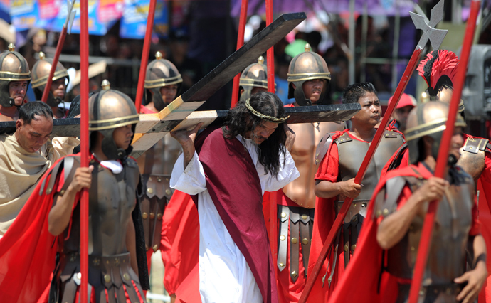 Philippine Christian devotee Ruben Enaje (C), carries a wooden cross during a re-enactment of the crucifixion of Jesus Christ on Good Friday in San Fernando City, Pampanga province, north of Manila on March 29, 2013 (AFP Photo / Noel Celis)
