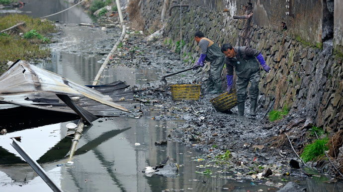 Workers clear away rubbish along a river in Rui'an, Zhejiang province.(Reuters / China Daily)