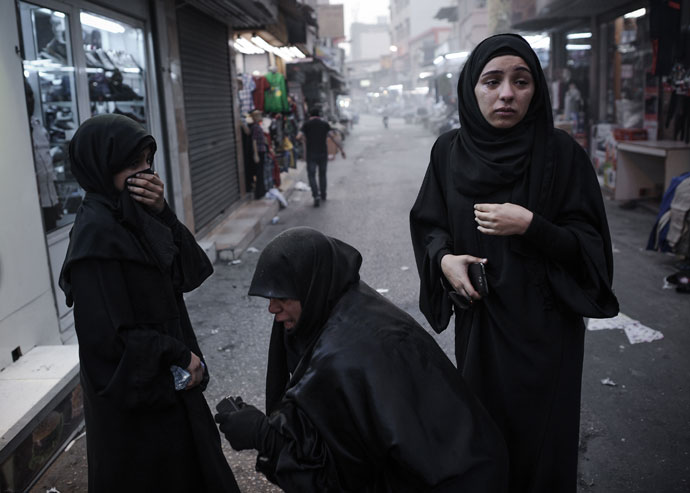 Bahraini women react after inhaling tear gas fired by riot police during an anti-regime rally in solidarity with jailed human rights activist Nabeel Rajab and against the upcoming Bahrain Formula One Grand Prix in Manama on March 29, 2013.(AFP Photo / Mohammed AL-Shaikh)