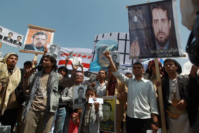 Relatives of Yemeni inmates held in the US detention center "Camp Delta" at the US Naval Base in Guantanamo Bay, Cuba, brandish their portraits during a protest to demand their release, outside the American Embassy in Sanaa, on April 1, 2013.(AFP Photo / Mohammed Huwais)