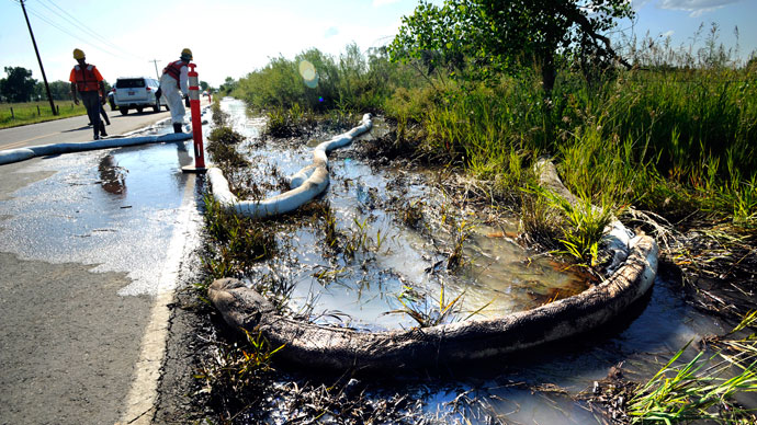 An emergency response crew hired by Exxon Mobil clean up an oil spill with an absorbent boom along the Yellowstone River in Laurel, Montana, July 5, 2011.(Reuters / John Warner)