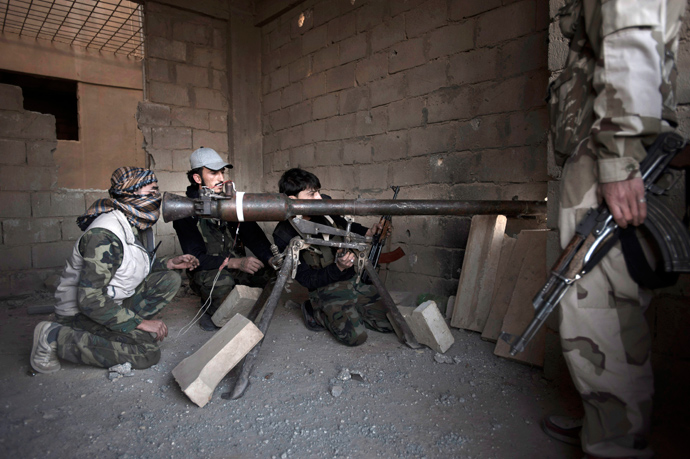 Syrian rebels prepare to launch a rocket towards an adjacent government held building in Hwaka, a neighborhood of Deir Ezzor (AFP Photo / Zac Baillie)