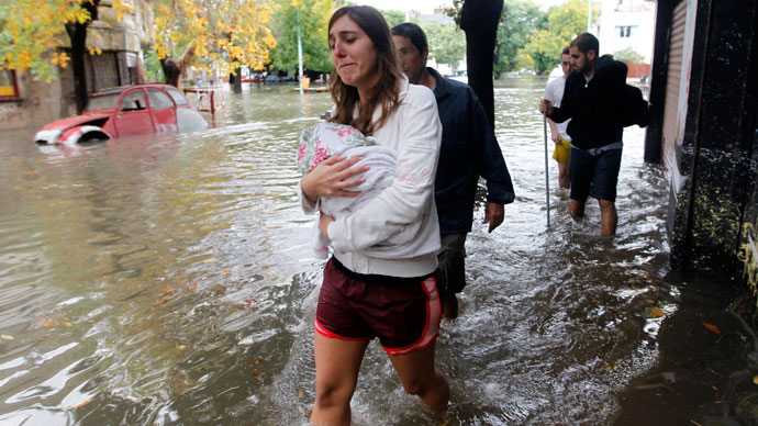 People wade through a flooded street after a rainstorm in Buenos Aires April 2, 2013.(Reuters / Enrique Marcarian)