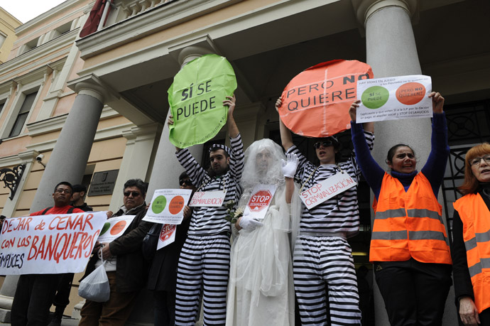 Anti-eviction activists, some of them dressed up as prisoners or as a bride, take part in a protest to demand the vote of a Popular Legislative Initiative (ILP) to stop evictions, regulate dation-in-payment and establish social rents, in front of a municipal building of Vallecas, office of Madrid's deputy Eva Duran, in Madrid on April 3, 2013. (AFP/Photo)