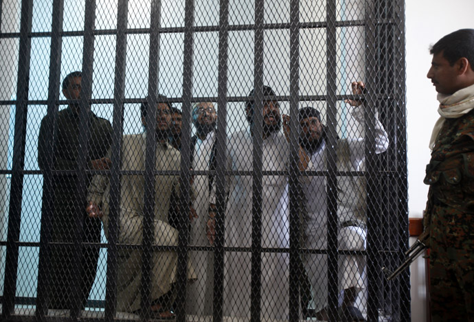 Police troopers (L and R) stand guard as defendants look from behind bars as verdicts are being pronounced at the courtroom of a state security court of appeals in Sanaa February 12, 2013. The court on Tuesday upheld jail sentences of periods between one to five years against seven defendants over al Qaeda links, the state Saba news agency reported. (Reuters)