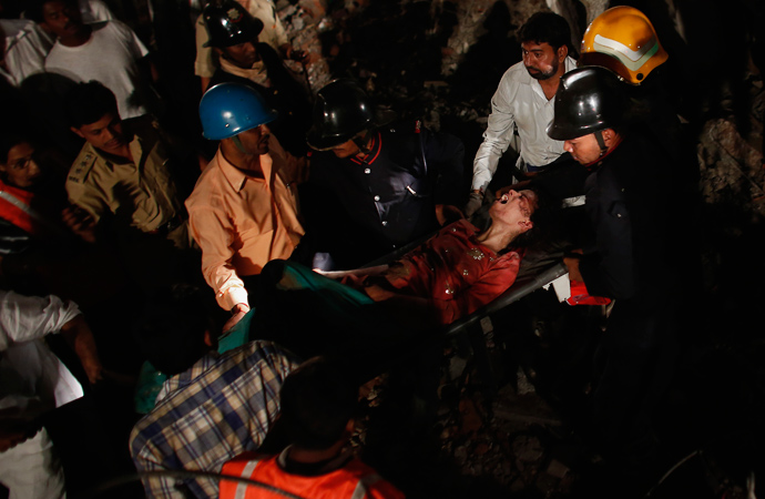 Rescue workers carry a woman who survived from a collapsed residential building in Thane, on the outskirts of Mumbai April 4, 2013 (Reuters / Danish Siddiqui) 