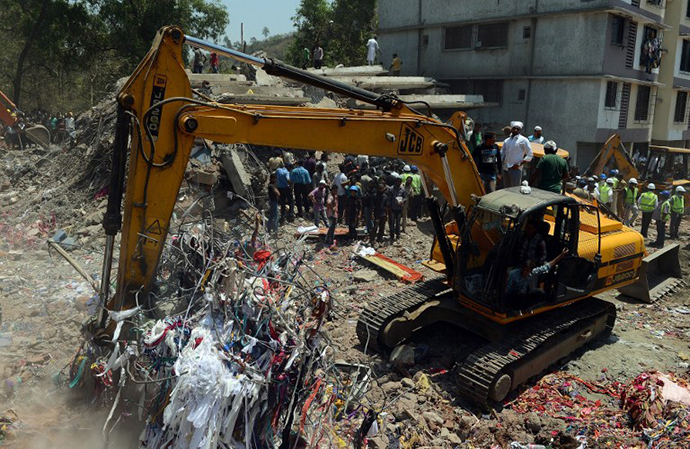 An excavator clears the debris at the site of building collapse in Thane, on the outskirts of Mumbai on April 5, 2013. (AFP Photo / Punit Paranjpe)