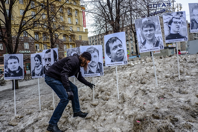 A man stands next to pictures of jailed opposition supporters during a rally in central Moscow on April 6, 2013. (RIA Novosti / Andrei Stenin)